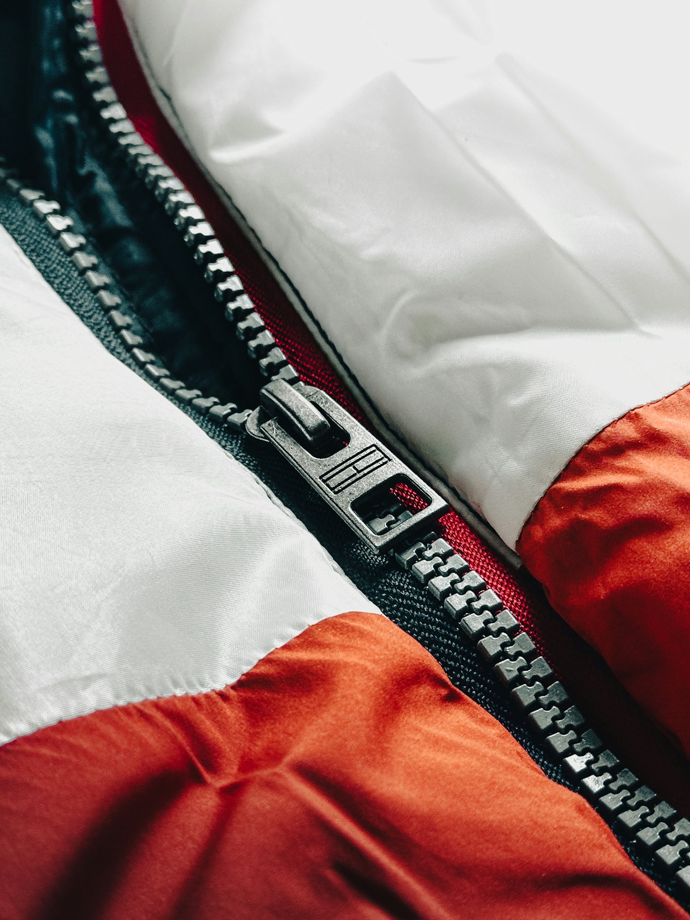 Close-up of a quilted puffer jacket showing channel stitching and a metal zipper